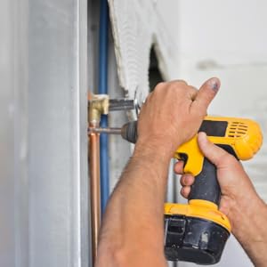 person using screwdriver on wall